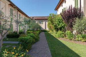 a garden with a path between two buildings at Appartamenti Palazzo Scolari in Polpenazze del Garda
