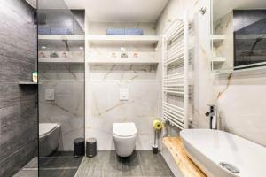 La salle de bains blanche est pourvue de toilettes et d'un lavabo. dans l'établissement Cozy renovated apartment close to Schoenbrunn Palace, à Vienne