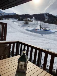 ein Licht auf einer Terrasse mit einer Skipiste in der Unterkunft Appartement à Enchastrayes sur piste station de ski au Sauze à 3km de Barcelonnette in Enchastrayes