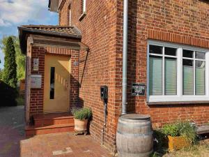 een stenen huis met een vat naast een deur bij Ferienwohnung Klosterquartier in Lüneburg