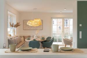 a dining room and living room with a table and chairs at Landhaus John in Oldsum