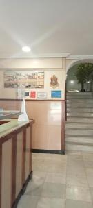 vestíbulo con escalera y recepción en Hostal Bahía en Cádiz