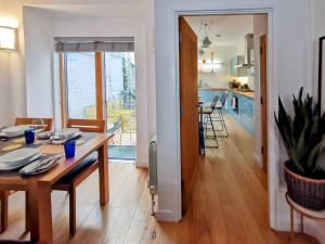 Un comedor y una sala de estar con una mesa y una cocina. en Beautiful central townhouse w/ parking for 2 cars, en Brighton & Hove