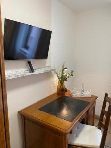 a wooden table with a television on a wall at Hotel Zur Linde in Saarlouis