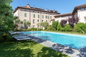 a swimming pool in front of a large building at Appartamenti Palazzo Scolari in Polpenazze del Garda