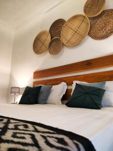 a bedroom with a bed with baskets on the wall at Amel House in Gili Air