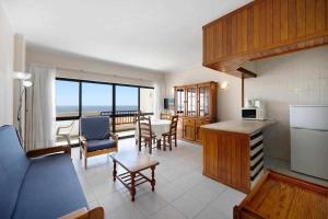 a kitchen and living room with a view of the ocean at Apartamentos Torre da Rocha frente ao mar in Portimão