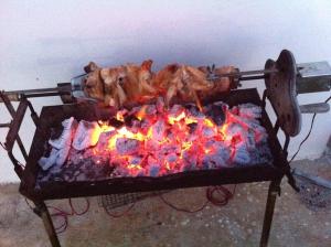 un pollo está cocinando en la parte superior de una parrilla en Sunray Villa - Luxury Villa with Private Pool, en Argaka