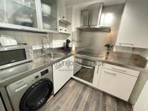 uma cozinha com uma máquina de lavar roupa e um lavatório em A morada das perseidas em Ourense
