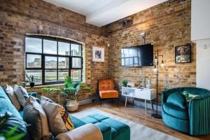 a living room with a brick wall at Livestay-Fabulous Three Bed Warehouse Conversion Apartment in London