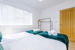 マンチェスターにあるLovely 3 Bed house - Park Laneのベッドルーム1室(大きな白いベッド1台、タオル付)
