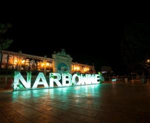 a large sign in front of a building at night at Appartement - Narbonne in Narbonne