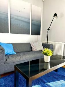 a living room with a couch and a glass coffee table at Przystanek Sopot Plaża in Sopot