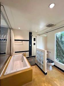 a large bathroom with a tub and a toilet at Sandhana Samet Resort in Ko Samed