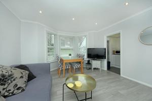 a living room with a couch and a table at Ealing Garden Flat in Ealing
