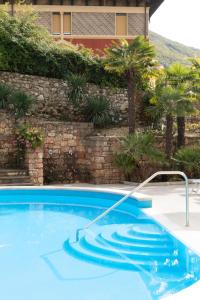 a swimming pool in front of a building at Hotel Drago - Garda Lake Collection in Brenzone sul Garda
