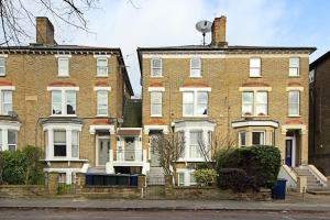 two large brick houses on the side of a street at Ealing Garden Flat in Ealing