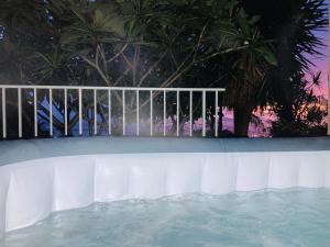 - une piscine avec une clôture et des arbres la nuit dans l'établissement Ty Lodge La Réunion, vue mer, Spa, 30 mn du lagon, à Le Tampon