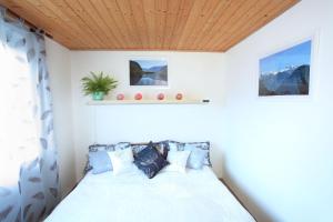 - une chambre avec un lit et un plafond en bois dans l'établissement Untersee24 - Lake Hallstatt Apartment, à Bad Goisern