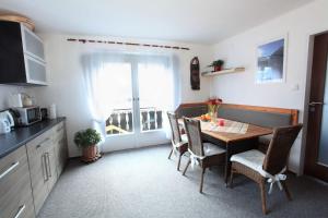 une cuisine avec une table à manger, des chaises et une fenêtre dans l'établissement Untersee24 - Lake Hallstatt Apartment, à Bad Goisern