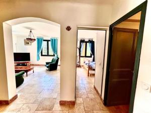 a living room with a door and a room with a couch at Grand appartement en face du village in Moustiers-Sainte-Marie