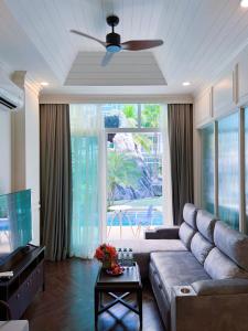 a living room with a couch and a large window at Grand Florida Pattaya By TheBest Management in Na Jomtien