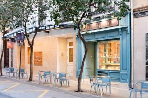 a group of chairs and tables in front of a store at Hotel Sauce in Zaragoza