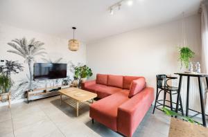 a living room with a red couch and a tv at Bohema Place - Metro Szwedzka Apartment in Warsaw