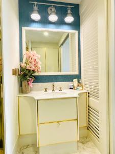 ein Bad mit einem Waschbecken und einem Spiegel in der Unterkunft Grand Florida Pattaya By TheBest Management in Na Jomtien