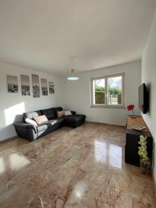 a living room with a couch and a television at La Terrazza Baldo Garda in San Zeno di Montagna