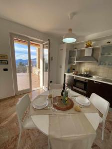 a white table and chairs in a kitchen with a view at La Terrazza Baldo Garda in San Zeno di Montagna