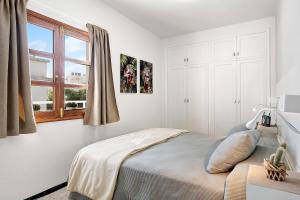 Un dormitorio blanco con una cama y una ventana. en Apartamento La Estrella 4, en Arrecife