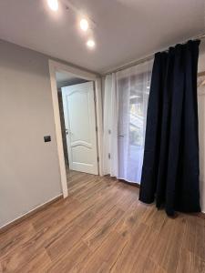 ein leeres Wohnzimmer mit einer Tür und einem Fenster in der Unterkunft Cabana B2 langa strandul Banffy in Topliţa