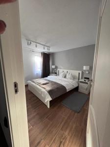a bedroom with a large bed and a wooden floor at Cabana B2 langa strandul Banffy in Topliţa