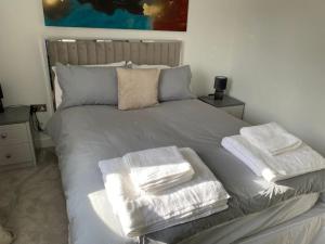 a bed with two towels on top of it at Hömli Close2City Apartment in Faygate