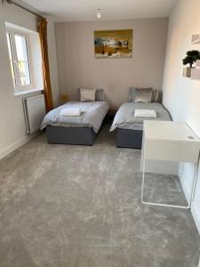 a room with two beds and a table in it at Hömli Close2City Apartment in Faygate