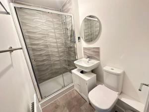 a bathroom with a shower and a toilet and a sink at Hömli Close2City Apartment in Faygate