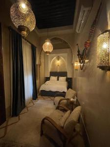 1 Schlafzimmer mit einem Bett, 2 Stühlen und Beleuchtung in der Unterkunft Riad AL Bahi in Rabat