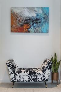 a couch in a room with a painting on the wall at Luxury Spacious Flat with Communal Gardens and Parking in London