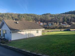 a small white house with a large yard at Nice guesthouse with heat floor in Lilla Edet