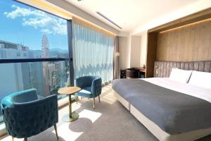 札幌市にある ザ ノット 札幌のベッドと大きな窓が備わるホテルルームです。