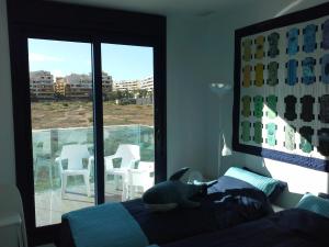 a cat laying on top of a bed in a bedroom at Super zeezicht in eerste lijn met verwarmd zwembad en fitness in Punta Prima +51 photos