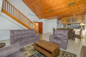 a living room with two couches and a table at San Lameer Villa 10301 - 4 Bedroom Classic - 8 pax - San Lameer Rental Agency in Southbroom