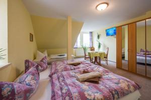 ein Schlafzimmer mit einem großen Bett und einem Tisch in der Unterkunft Gasthaus & Pension St.Peter in Eisenach