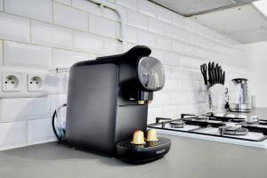 eine Kaffeemaschine auf einer Küchentheke in der Unterkunft Grand Appartement aux Portes de Paris in Aubervilliers