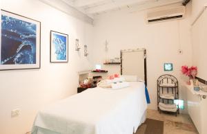a hospital room with a white bed and a chair at Cyprus Villages Hotel & Restaurant - Central Location - Bed & Breakfast - With Access To Pool And Stunning Views in Tochni