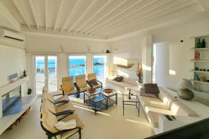 una sala de estar con sofás y sillas y el océano en Villa Pastorale-View-Boule Bahn, en Agia Irini Paros