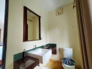 a bathroom with a sink and a mirror and a toilet at Sandhana Samet Resort in Ko Samed