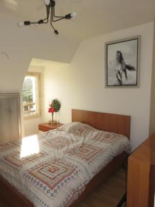 ein Schlafzimmer mit einem Bett und einem Bild an der Wand in der Unterkunft TY Lavarion in Le Bono