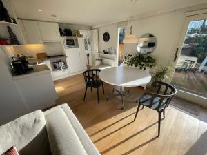 uma cozinha e sala de estar com mesa e cadeiras em Omheind prive 2 bedroom chalet VOORTHUIZEN VELUWE em Voorthuizen